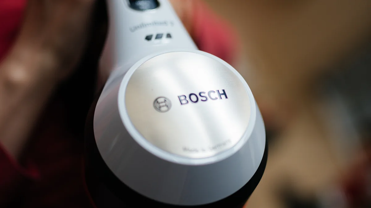 A cordless vacuum cleaning a modern living room in afternoon light